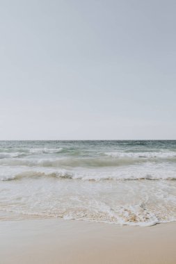 Phuket, Tayland dalgalar ile beyaz kum ve mavi deniz ile güzel tropikal plaj manzarası. Nötr renklerle minimal kompozisyon. Yaz konsepti. Doğal arka plan.
