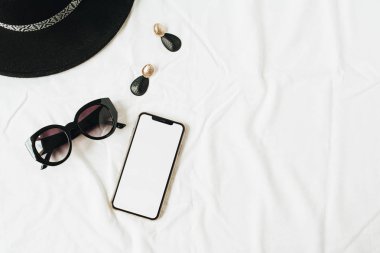 Düz yatıyordu, kopya alan telefon şablonu ile üst görünüm minimal kadın moda yaşam tarzı kolaj, şapka, güneş gözlüğü, beyaz keten küpe. Bayan patron güzellik blog arka plan.