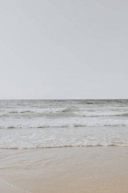 Phuket, Tayland dalgalar ile beyaz kum ve bej deniz ile güzel tropikal plaj manzarası. Nötr renklerle minimal kompozisyon. Yaz konsepti.