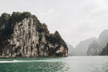 Cheow Lan Gölü, Khao Phang, Ban Ta Khun District, Tayland kayalar ve yeşil göl ile egzotik ve tropikal koyu yeşil adalar. Seyahat tatil ve macera konsepti.