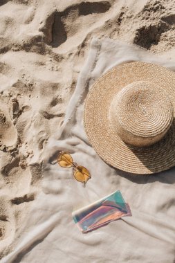 Beyaz kum, ayak adımları, hasır şapka, güneş gözlüğü ve durumda ile nötr battaniye ile Tropikal güzel plaj. Rahatlatıcı bir atmosfer. Yaz seyahati veya tatil konsepti. Minimalist arka plan.