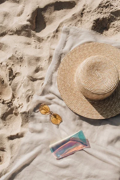 Beyaz kum, ayak adımları, hasır şapka, güneş gözlüğü ve durumda ile nötr battaniye ile Tropikal güzel plaj. Rahatlatıcı bir atmosfer. Yaz seyahati veya tatil konsepti. Minimalist arka plan.