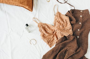Moda moda iç çamaşırı kompozisyon. Sütyen, parfüm, beyaz keten arka planda gece elbisesi. Düz yatıyordu, üst görünüm güzellik blog / sosyal medya minimal kavramı.