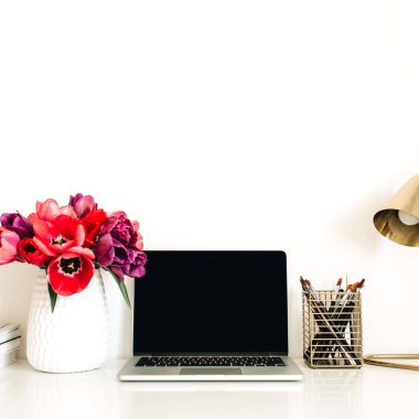 Dizüstü bilgisayar, lale çiçekleri buket, kırtasiye, lamba ile Ev ofis çalışma alanı arka plan. Kopya alanı şablonu ile Minimalist bayan patron blog kahraman başlık. Yaşam tarzı natürmort kavramı.