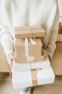 Noel / Yeni Yıl hediye kutuları ve kadın ellerinde fiyonklar. Geleneksel kış tatilleri yaratıcı paketleme konseptini sunar.