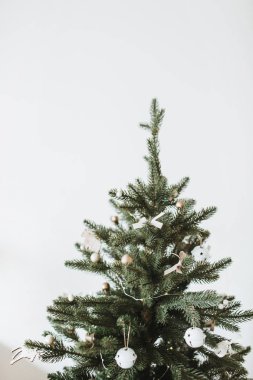 Noel, Noel ağacı oyuncaklarla süslenmiş, Noel baloları, beyaz arka planda fiyonklar. Kış tatili en düşük kompozisyon.