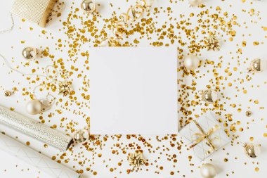 Noel, yeni yıl kompozisyonu. Fotokopi alanı, Noel mücevherleri, hediye kutusu, süs, beyaz arka planda altın süslemesi olan kare boş çerçeve. Düzlük, üst görünüm bayram modeli..