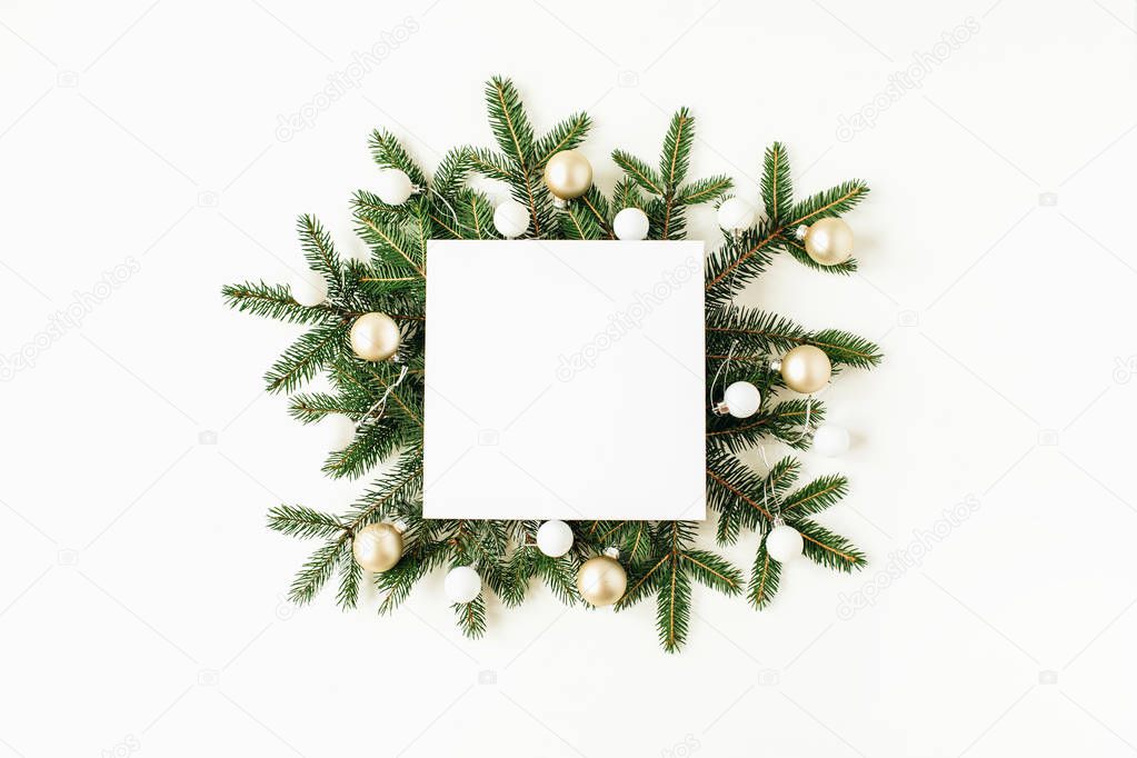 Christmas / New Year composition. Square mock up frame with blank copy space, fir branches, Christmas balls on white background. Flat lay, top view festive holiday concept.