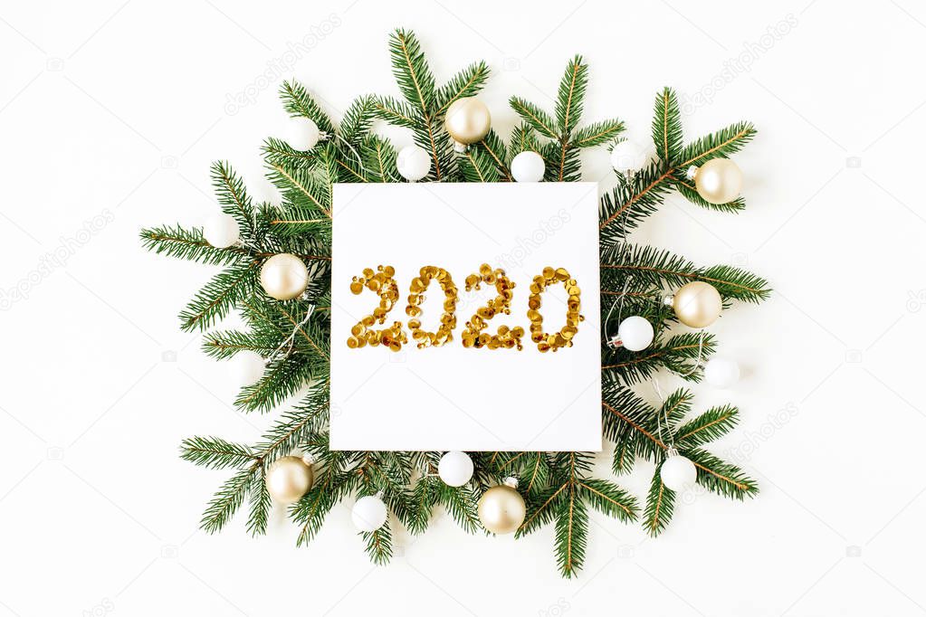 Christmas, New Year composition. Square frame with number 2020, Christmas baubles, fir needle branches on white background. Flat lay, top view festive holiday concept.