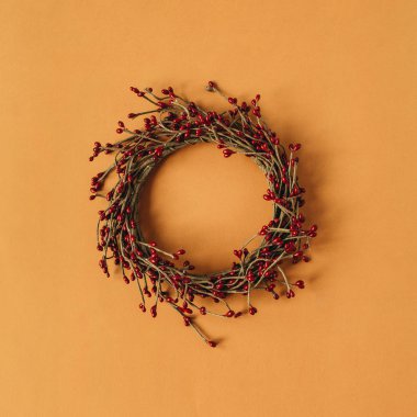 Kızıl arkaplanda kırmızı böğürtlenlerden yapılmış boş fotokopi alanı olan çelenk çerçevesi. Düzlük, üst görünüm Noel / Yeni Yıl Minimum konsepti.