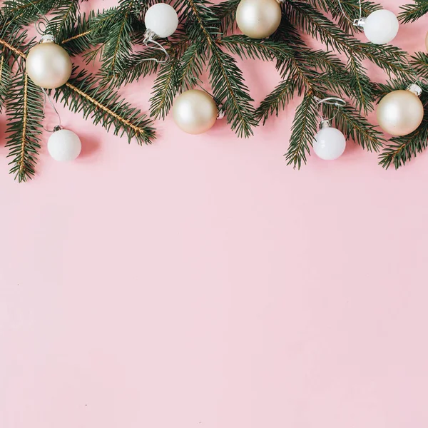 Christmas / New Year holiday composition. Hero header with blank copy space, fir needle branches, Christmas baubles on pink background. Flat lay, top view festive concept.