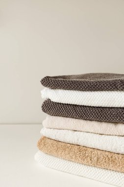 Katlanmış banyo havluları beyaz masaya dizilmiş. Minimum hijyen kavramı.