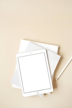 Bej arkaplanlı boş ekranlı tablet. Düz konum, üst görünüm kopyalama alanı olan boş maket