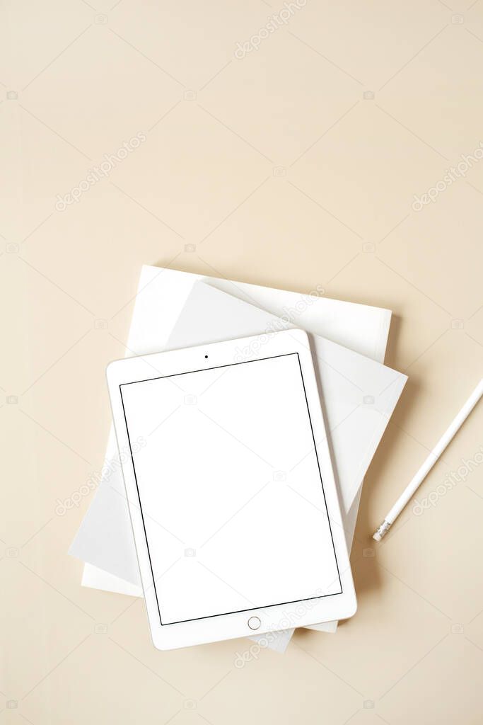 Tablet pad with blank screen on beige background. Flat lay, top view empty mockup with copy space