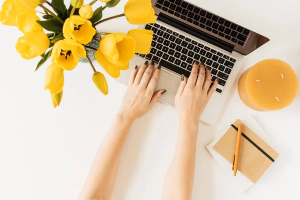 ノートパソコンで働く女性 ラップトップ付きのホームオフィスデスクワークスペース チューリップの花は白い背景に花束 フラットレイアウト トップビュー オーバーヘッドビュー — ストック写真