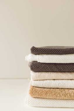 Katlanmış havlular beyaz arka planda yığılır. Sağlık, hijyen, sağlık kompozisyonu.