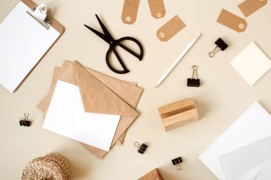 Bej masasında zarflı boş kağıt. Sanatçının çalışma masası ahşap tabut, kalem ve kırtasiye malzemesi. Ağlı davetiye kartı. Düz yatış, boş kopyalama alanı olan üst görünüm modeli