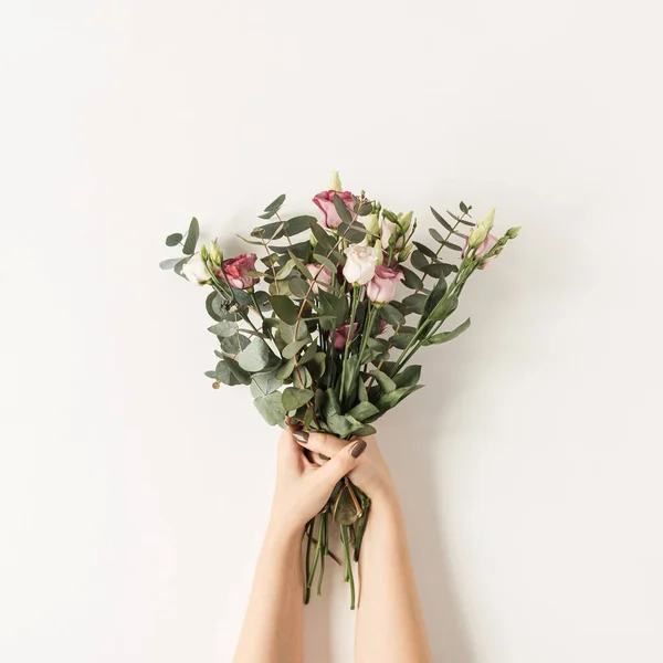 白い壁にカラフルなバラの花花束を保持する女性の手 お祝いの花のコンセプト — ストック写真