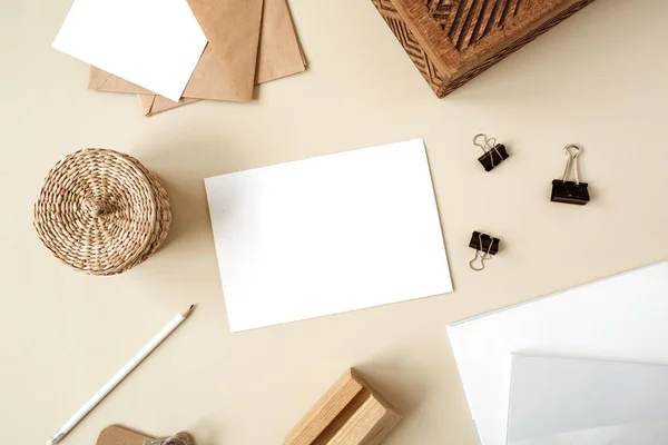 米色桌子上的空白纸片 艺术家的家庭写字台工作空间用木盒 信封和文具 Webbing邀请卡 平面布局 顶部视图模型与空复制空间 — 图库照片