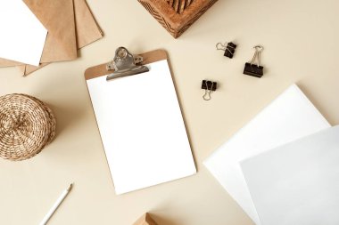 Pano tableti ve bej masa üzerinde boş kağıt levha. Sanatçının çalışma masası ahşap tabut, kalem, zarf ve kırtasiyeyle dolu. Düz yatış, boş kopyalama alanı olan üst görünüm modeli