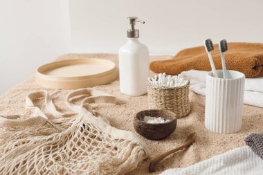 Diş macunu, havlu, toz, diş fırçası, bej havlunun üzerinde sıvı sabun. Kadın güzellik tedavi rutin konsepti