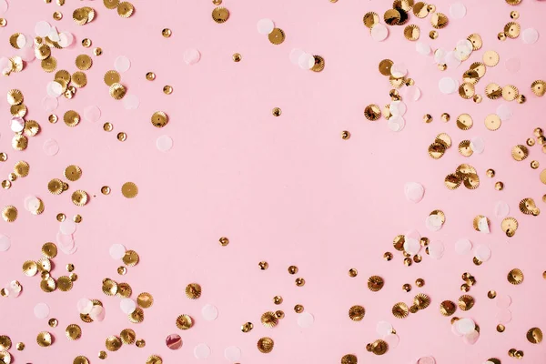 Background of colorful gold sparkling confetti with mockup frame on pink background. Festive holiday concept. Christmas. Wedding. Birthday. Mothers Day. Valentine\'s Day. Flat lay, top view