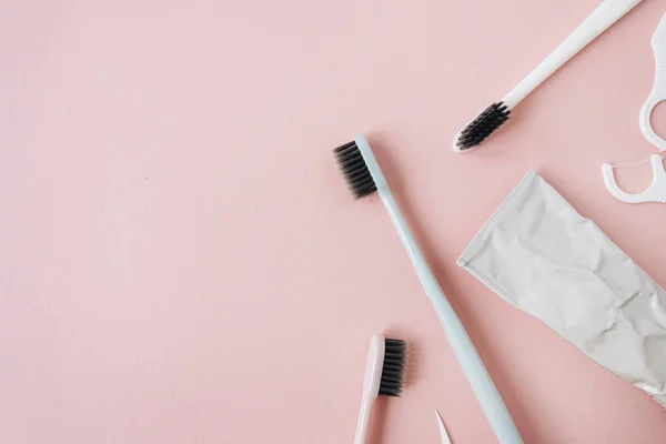 Zahnbürsten Zahnpasta Zahnseide Auf Rosa Hintergrund Flache Lage Mundpflege Von — Stockfoto