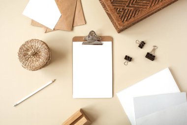 Pano tableti ve bej masa üzerinde boş kağıt levha. Sanatçının çalışma masası ahşap tabut, kalem, zarf ve kırtasiyeyle dolu. Düz yatış, boş kopyalama alanı olan üst görünüm modeli