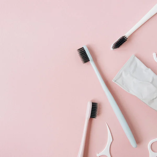 Mundpflegeprodukte Zahnbürsten Zahnpasta Zahnseide Auf Rosa Hintergrund Flache Lage Draufsicht — Stockfoto