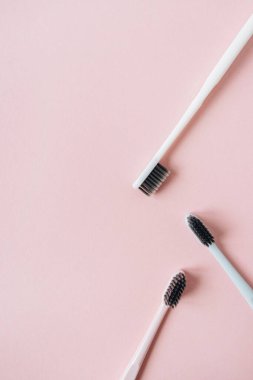 Pembe arka planda diş fırçaları. Düz yatış, üst görünüm minimum ağız bakımı, diş hijyeni konsepti