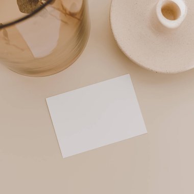 Sahte kopya alanı olan boş kağıt kağıtlar, bej arka planda cam vazoda okaliptüs dalları. Düz konum, üst görünüm minimal ticari marka şablonu