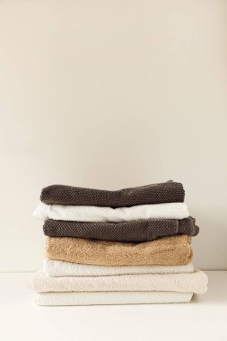 Katlanmış havlular beyaz arka planda yığılır. Sağlık, hijyen, sağlık kompozisyonu.