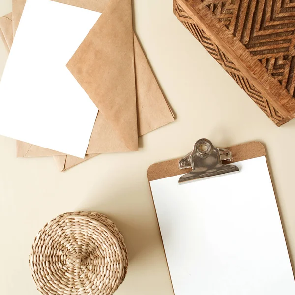 Pano tableti ve bej masa üzerinde boş kağıt levha. Sanatçının çalışma masası ahşap tabut, kalem, zarf ve kırtasiyeyle dolu. Düz yatış, boş kopyalama alanı olan üst görünüm modeli