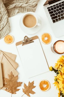 Sarı papatya çiçekleri buketi, kahve fincanı, portakal dilimleri ve ekoseyle süslenmiş ofis masası çalışma alanı. Düz konum, üst görünüm serbest iş konsepti sosyal medya, dergi.