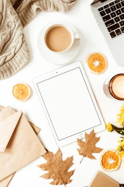 Boş fotokopi tableti, dizüstü bilgisayar, kahve fincanı, battaniye, zarflar ve beyaz arkaplanda yaprakları olan düz bir ofis masası çalışma alanı. Üst düzey kız patron işi, iş konsepti..