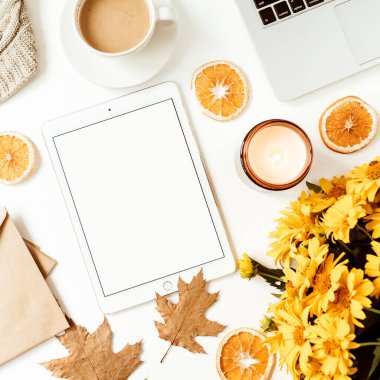 Ofis masası çalışma alanı. Kopya alanı olan boş ekran tableti. Sarı papatya çiçeği buketi, portakal dilimleri. Düz konum, üst görünüm serbest iş konsepti sosyal medya, dergi.