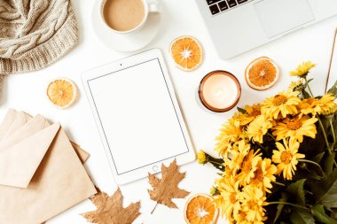 Ofis masası çalışma alanı. Kopya alanı olan boş ekran tableti. Sarı papatya çiçeği buketi, portakal dilimleri. Düz konum, üst görünüm serbest iş konsepti sosyal medya, dergi.
