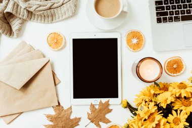 Ofis masası çalışma alanı. Kopya alanı olan boş ekran tableti. Sarı papatya çiçeği buketi, portakal dilimleri. Düz konum, üst görünüm serbest iş konsepti sosyal medya, dergi.