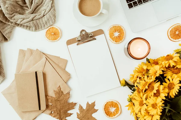 Sarı papatya çiçekleri buketi, kahve fincanı, portakal dilimleri ve ekoseyle süslenmiş ofis masası çalışma alanı. Düz konum, üst görünüm serbest iş konsepti sosyal medya, dergi.
