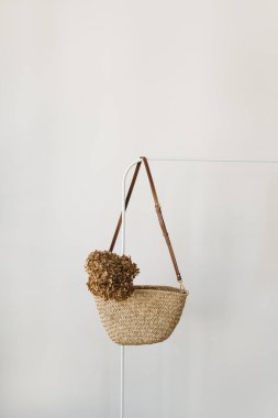 Zarif moda aksesuarı. Askıda kurutulmuş ortanca çiçekli saman el çantası. Moda günlüğü, kopyalama alanı olan sosyal medya şablonu