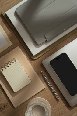 Ofis çalışma alanı. Akıllı telefon, dizüstü bilgisayar, tablet, tahta masadaki defter. Estetik iş markası. Düz yerde, üst tarafta. Boş kopyalama alanı