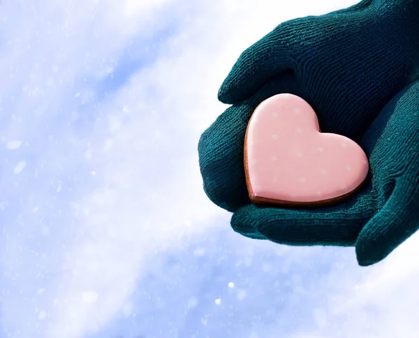 cropped image of woman in gloves holding pink heart symbol
