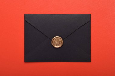 Kırmızı arkaplanda balmumu mühürlü siyah zarf