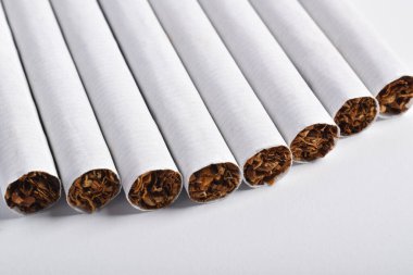 Beyaz arka planda izole edilmiş sigaralar. Kötü alışkanlıklar. Sigara içmek akciğer kanserine yol açar