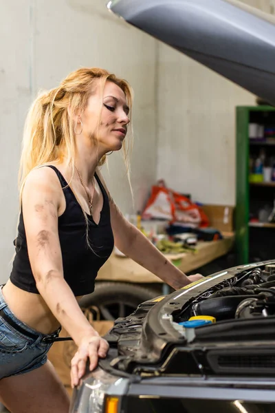 Une fille dans un service de voiture travaille avec des pneus — Photo