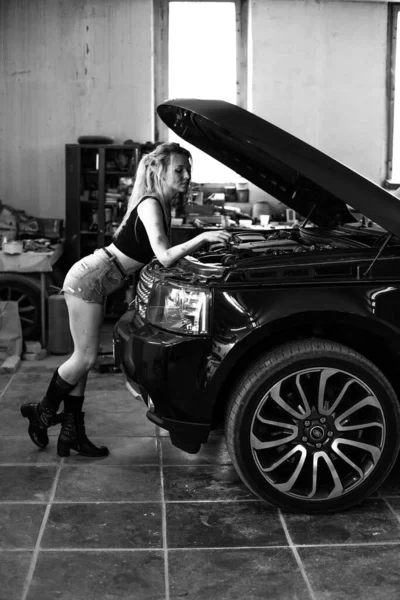 Una ragazza in un servizio di auto lavora con pneumatici — Foto Stock