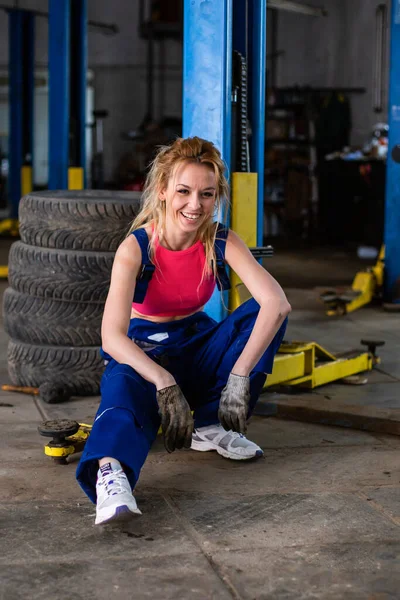 Una ragazza in un servizio di auto lavora con pneumatici — Foto Stock