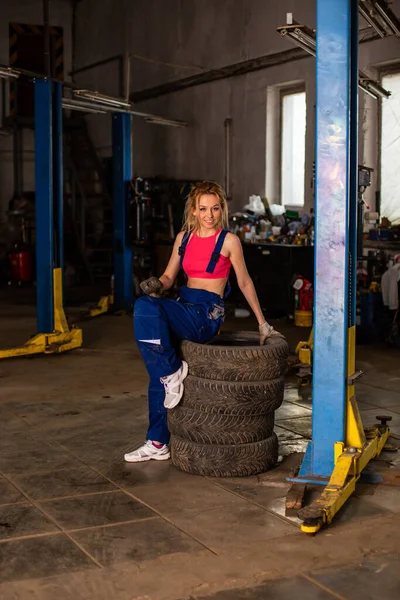 Dívka v automobilové službě pracuje s pneumatikami — Stock fotografie