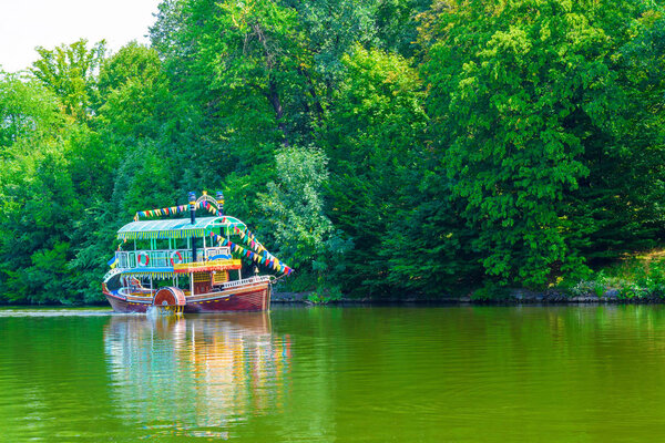 Photo of a beautiful tourist ship on a lake in a park at summer