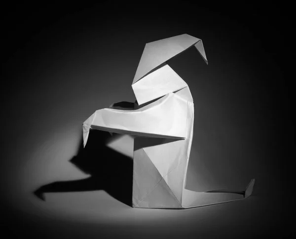 Photo of white origami ghost on black background